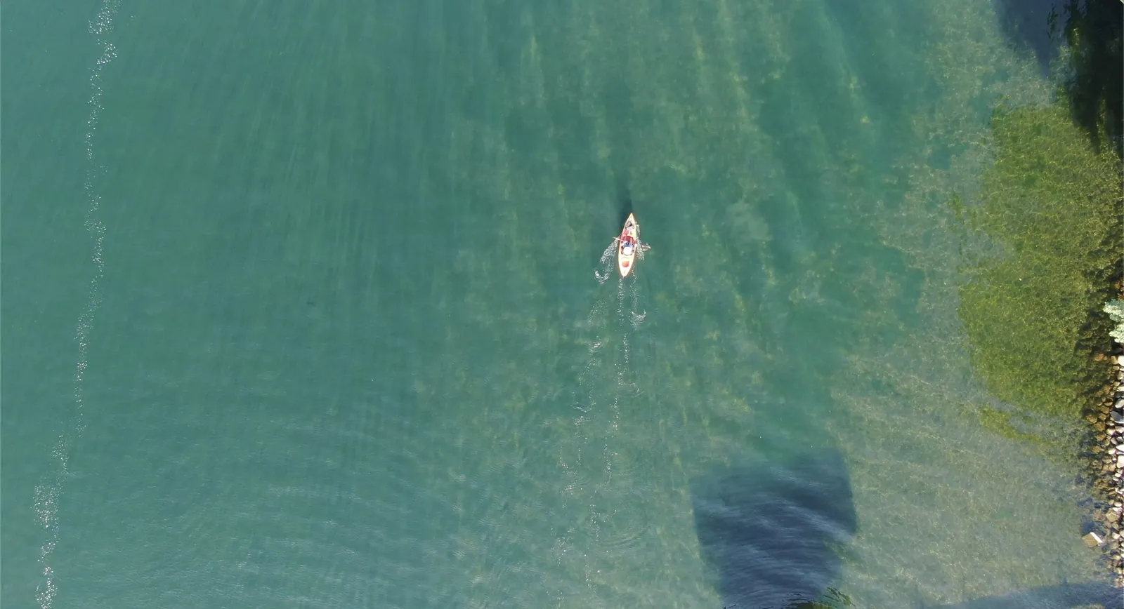 Kayaker over the clear blue-green water of West Lake Okoboji, Iowa