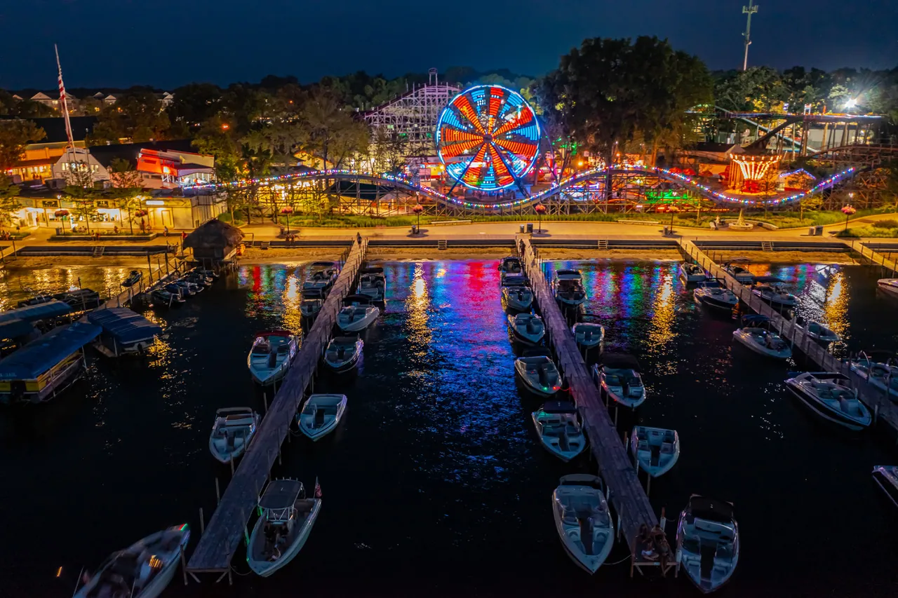 Marina slips and the lit amusement park at Arnolds Park on Lake Okoboji, Iowa at night