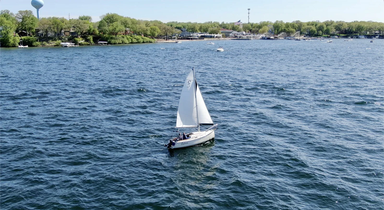 Sailboat passing lakeshore homes on West Lake Okoboji, Iowa